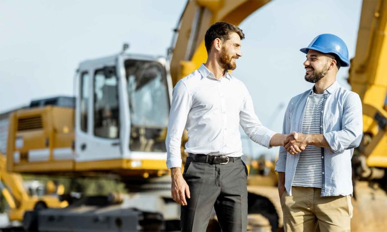 Zwei Männer auf Baustelle schütteln nicht sich Hand und unterhalten sich über die digitale Baustelle